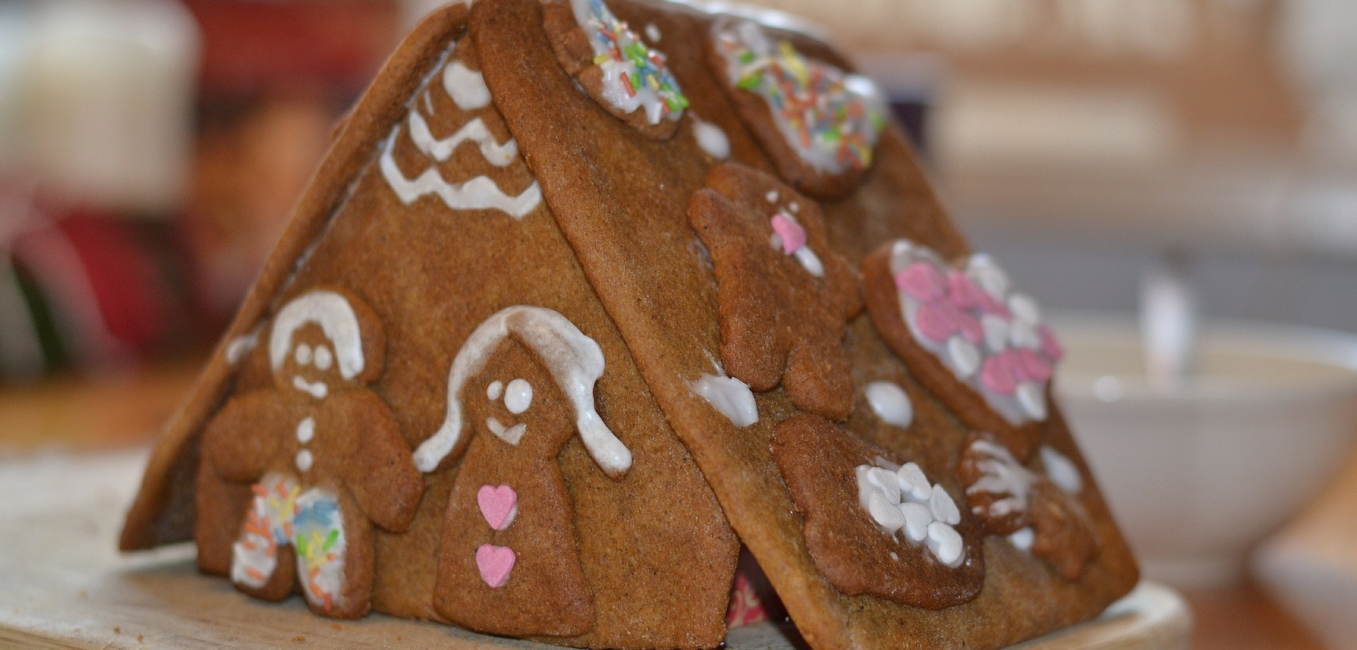 In Nahaufnahme wird ein Lebkuchenhaus gezeigt. Vor dem Eingang des Hauses steht ein Lebkuchen-Ehepaar